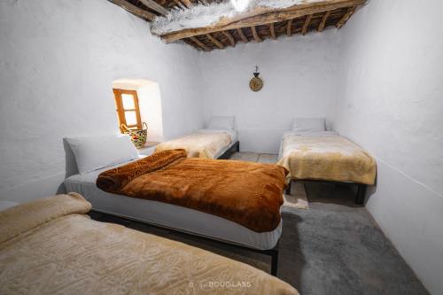 a room with three beds with brown blankets at Gîte OUHDOU in Midelt