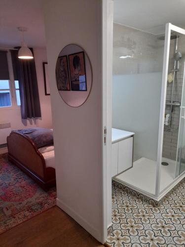 a bedroom with a bed and a mirror in a room at Beau Maison in Le Vigeant
