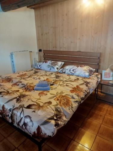 a bedroom with a bed with a floral bedspread at Il Nido in Valdisotto
