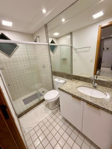 a bathroom with a toilet and a shower and a sink at Marulhos Resort in Porto De Galinhas