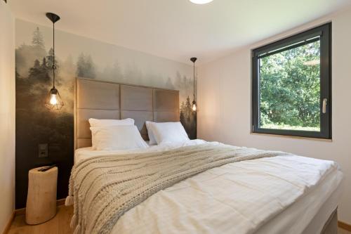 a bedroom with a large bed and a window at Chata 01 in Čeladná