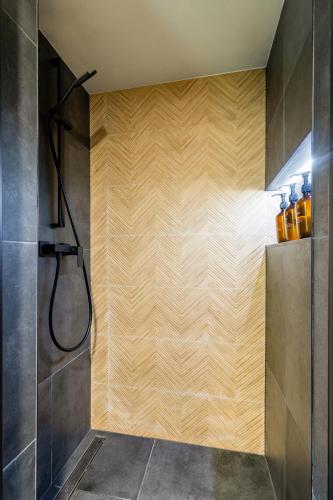 a bathroom with a shower with a wooden wall at Chata 01 in Čeladná