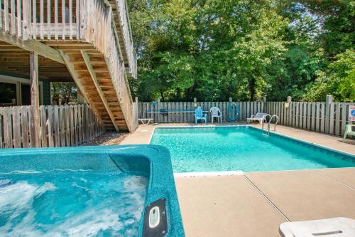a swimming pool in a yard next to a wooden fence at 3215 - Papa Duck in Duck