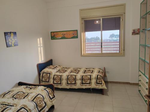 a bedroom with a bed and a window at Casa Mangiaracina in Porto Palo