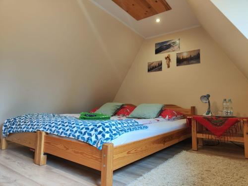 a bedroom with a bed and a table in a attic at Kraina Szczęśliwości in Zawoja