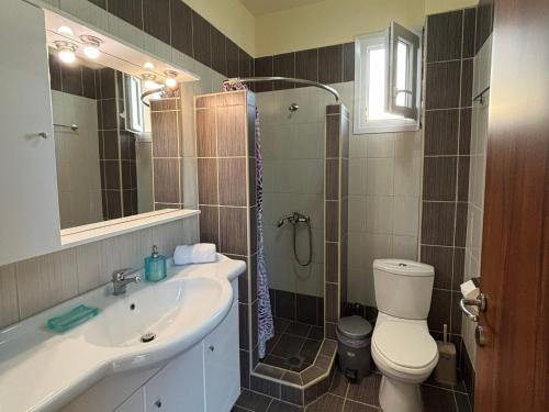 a bathroom with a toilet and a sink and a shower at Villa Beauty in Paliouri