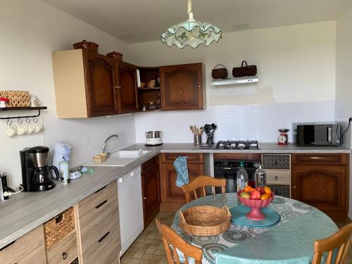 une cuisine avec une table sur laquelle se trouve un bol de fruits dans l'établissement belle vue, à Saint-Sauveur-de-Peyre