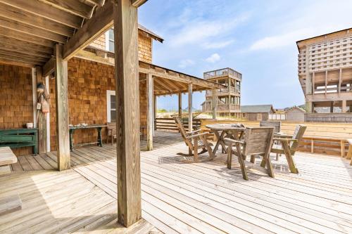 a wooden deck with a table and chairs at 5441 - Rascoe in Nags Head
