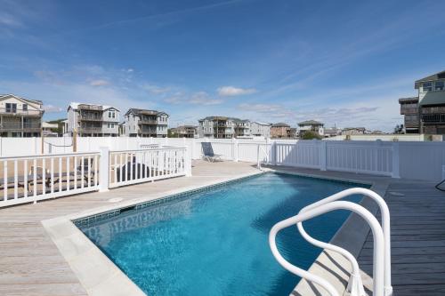 a swimming pool with a chair next to a house at 4759 - Sun Daze in Kitty Hawk Beach
