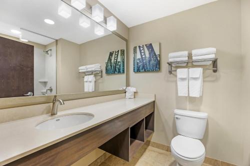 a bathroom with a sink and a toilet and a mirror at Best Western Plus Centralia Hotel & Suites in Centralia