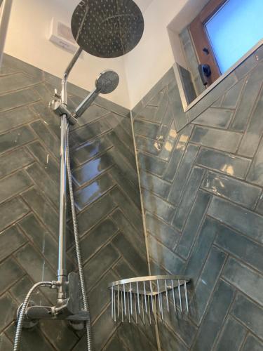 a shower with a shower head in a bathroom at Cortijo el Sendero in Alora
