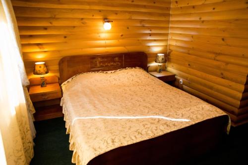 a bedroom with a bed in a wooden room at Gluhoman in Poltava