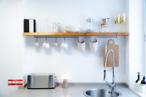 a kitchen counter with a shelf above a sink at Praia das Maçãs Sea view Retreat in Colares