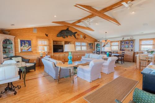 a living room with white furniture and wooden ceilings at 5451 - Richardson in Nags Head