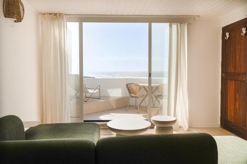 a living room with a couch and a view of the ocean at Praia das Maçãs Sea view Retreat in Colares