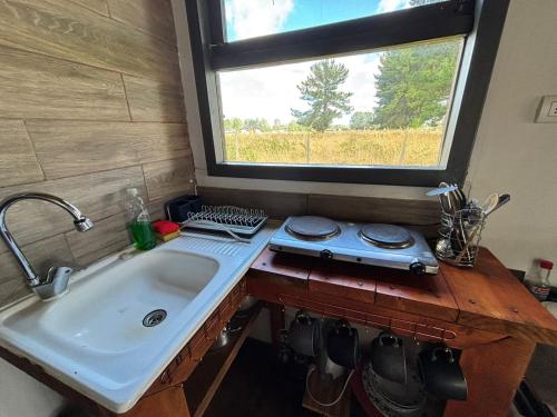 a kitchen counter with a sink and a window at Tiny House, Tiny Black Frutillar in Frutillar