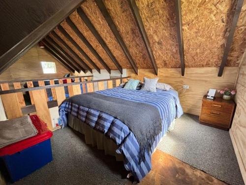 a bedroom with a bed in a wooden room at Tiny House, Tiny Black Frutillar in Frutillar