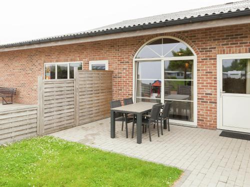a patio with a table and chairs in front of a brick building at Apartment in Groede near the Beach in Groede