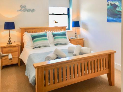 a bedroom with a bed with two pillows on it at Cove View Apartment in Porthcurno