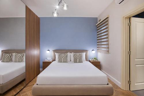 a bedroom with two beds and a mirror at NEW - Unique 3BR Apartment in Sought-After Area of Malta by SF Homes in Hal Ghaxiak