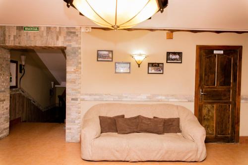 a living room with a couch and a chandelier at GALIRAD Hotel in Ustʼ-Kamenogorsk