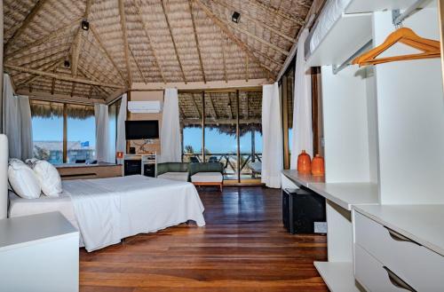 a bedroom with a bed and a living room at BobZ Boutique Resort in Barra Grande