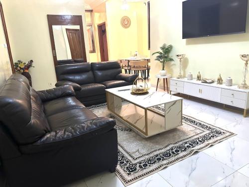 un soggiorno con divani in pelle e un tavolino da caffè di Residence Maria a Dakar