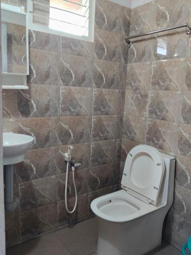 a bathroom with a toilet and a sink at Airin's Villa in Agali