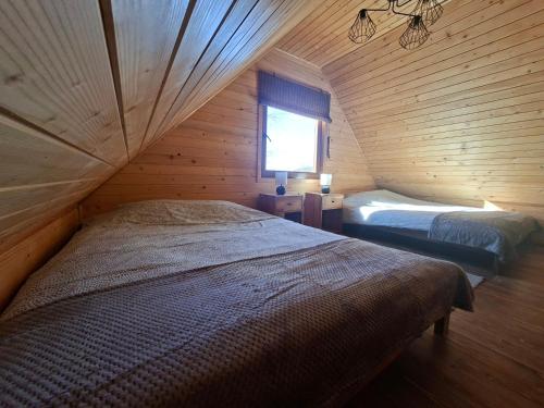 a bedroom with two beds in a wooden cabin at Pod Dębem in Winnica