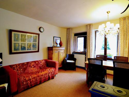 - un salon avec un canapé rouge et une table dans l'établissement Vintage Cottage with Shared Garden in Paliseul, à Paliseul