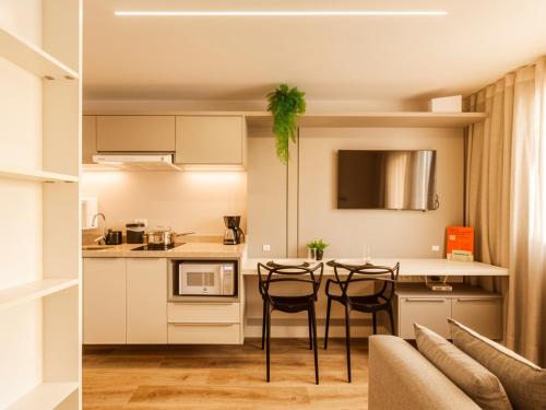 a kitchen and dining room with a table and chairs at Easy Life Campus PUC by Xtay - Estúdio completo próximo PUCPR in Curitiba