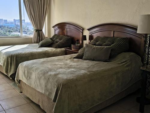 two beds in a bedroom with a window at Condo-Hotel on Collins ave in Sunny Isles Beach
