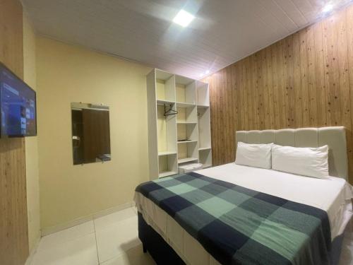 a bedroom with a bed and a tv in it at Pousada Corais de Pajuçara- MCZ in Maceió