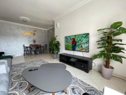 a living room with a table and a tv on a wall at Swiss Home in Agadir