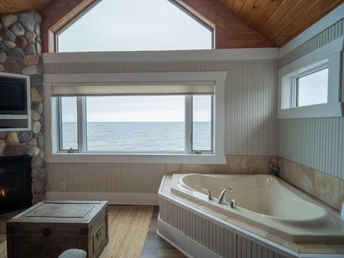 a bathroom with a tub and a large window at Grand Superior Lodge in Castle Danger