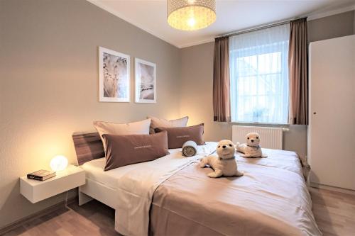 two dogs sitting on a bed in a bedroom at Ferienwohnung Strand-Domizil Zingst in Niederdorla