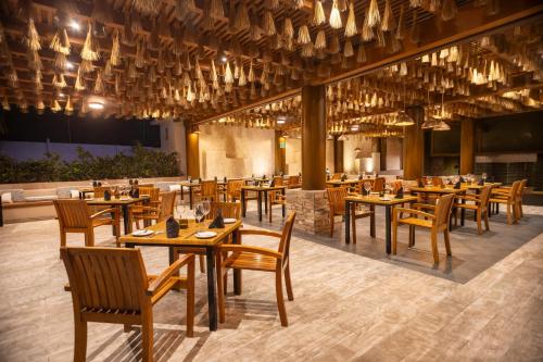 a dining room with wooden tables and chairs at Fiesta Americana Riviera Nayarit Resort All Inclusive & Spa in Nuevo Vallarta