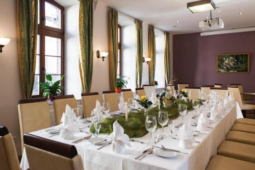 uma mesa longa com toalhas de mesa brancas e guardanapos em Hotel und Restaurant Haus Sajons em Plau am See