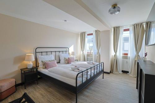 a bedroom with a bed with pink pillows at KasselRooms Comfort Studio in Kassel