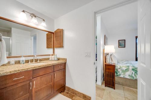 a bathroom with a sink and a mirror and a bed at Kahala 312 in Kipu