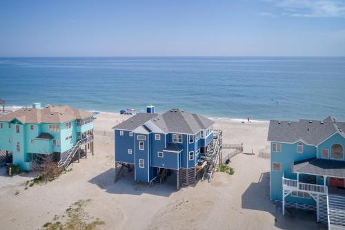 a group of blue houses on the beach at 7048 - Tide Song in Rodanthe