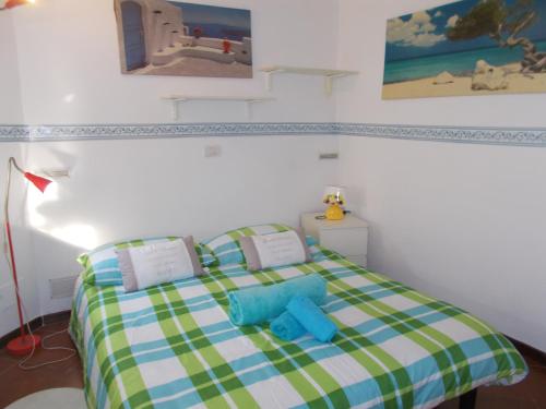 Dormitorio pequeño con cama con manta a cuadros en Il Granello di Senape B&B, en Palazzo Canavese