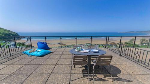 a table and chairs on a balcony with a view of the beach at Apt 16 Seaviews Slps 5 Indoor Heated Pool in Croyde
