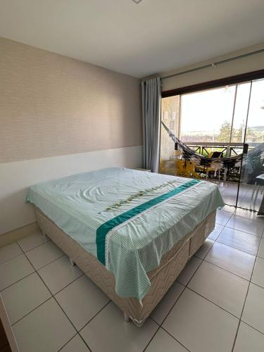 a bedroom with a bed in a room with a balcony at Flat 1218, no residencial monte castelo in Bezerros