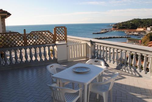 a table and chairs on a balcony with the ocean at Villa Fiorella in Castiglioncello