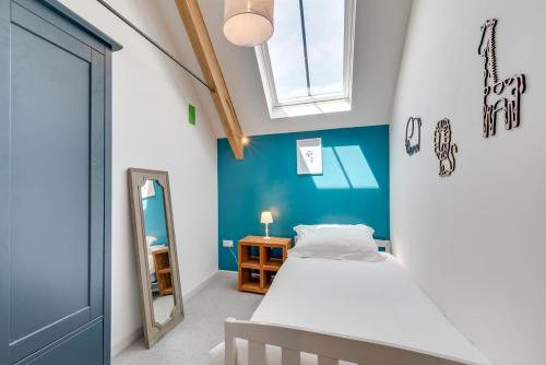 a bedroom with a bed and a blue wall at 5 Bed in Croyde oc-croydb in Croyde