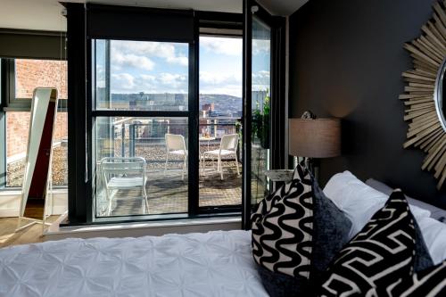 a bedroom with a bed and a view of a balcony at Deluxe City Centre Studio Apartment with Balcony & City Views - FREE WIFI NETFLIX, GYM ACCESS - WESTONE in Sheffield