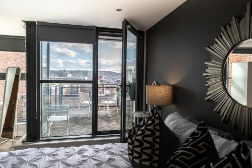 a room with a bed and a window with a view at Deluxe City Centre Studio Apartment with Balcony & City Views - FREE WIFI NETFLIX, GYM ACCESS - WESTONE in Sheffield