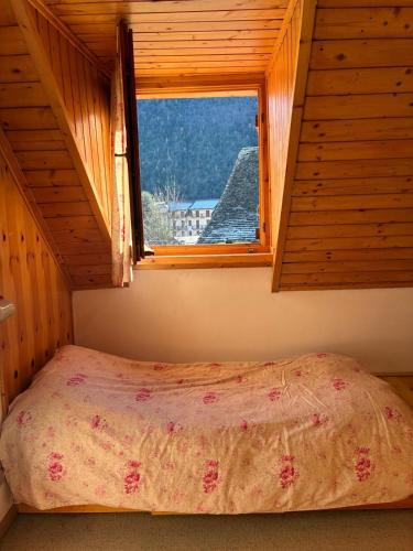 a bed in a room with a window at La mansarda in Santa Maria Maggiore