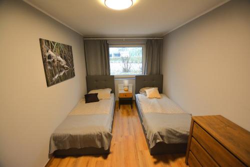 two beds in a small room with a window at Ośrodek Wypoczynkowy SUM in Bialokosz